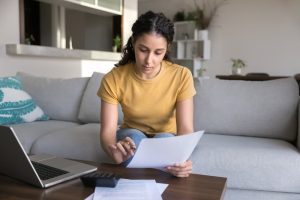 Homeowner reviewing bills and paperwork from a bad solar deal